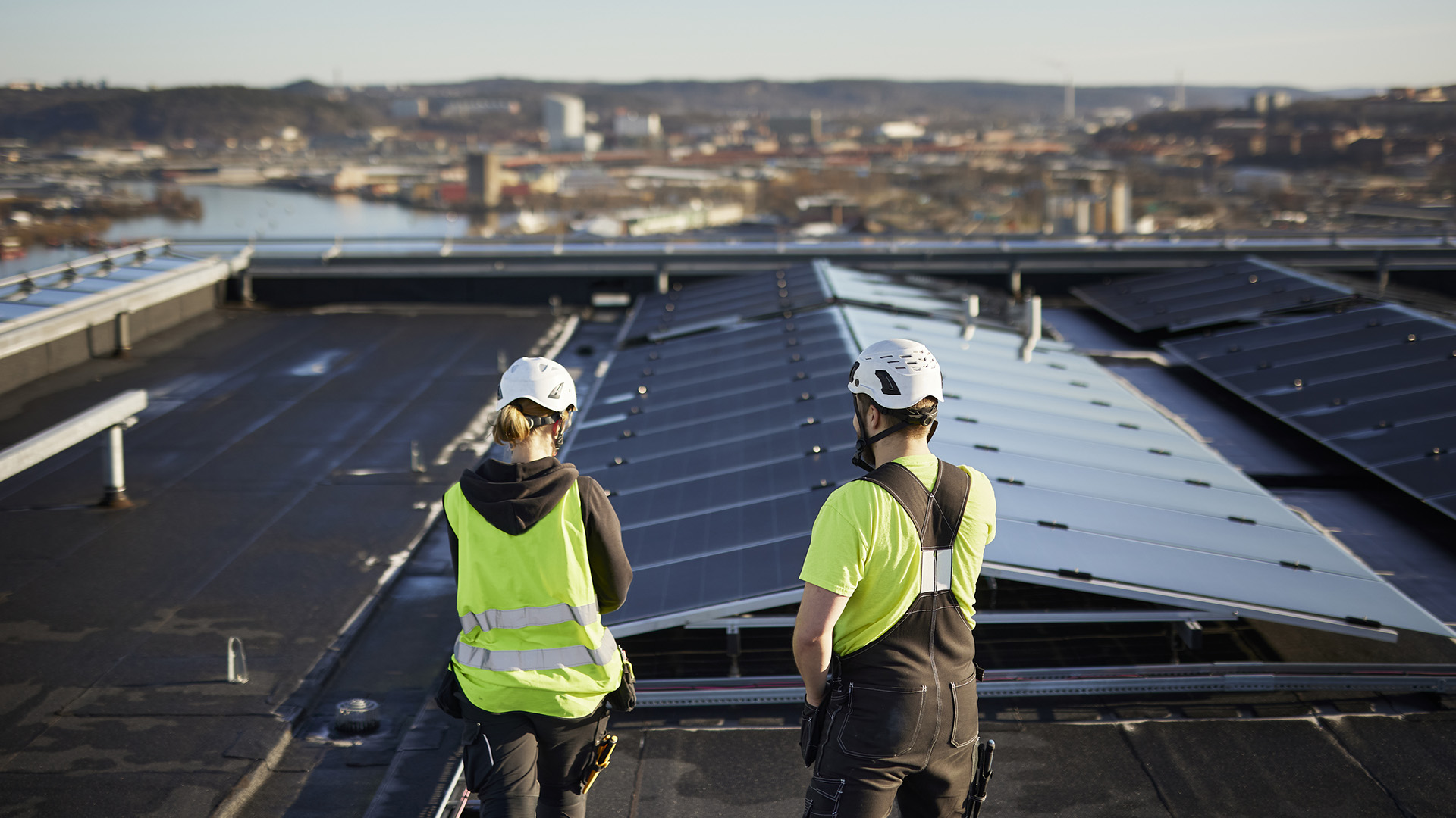 Genrebild på solcellsanläggning på tak, med två installatörer i förgrunden.